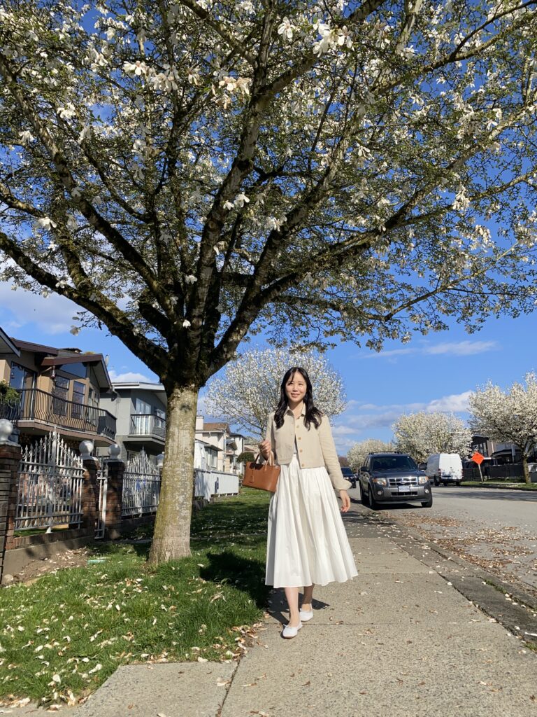 A woman's full body shot near magnolia tree 