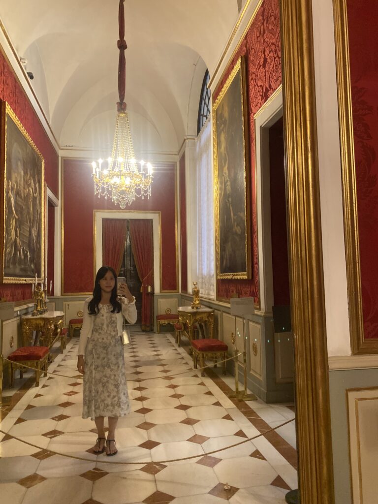 A woman taking mirror selfie in Royal Palace of Madrid